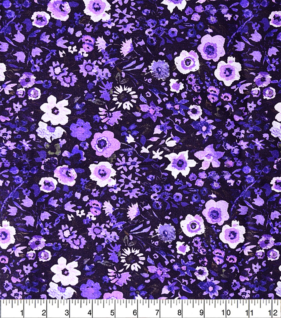 Floral fabric pattern with purple and white flowers on a dark background, measured with a ruler.