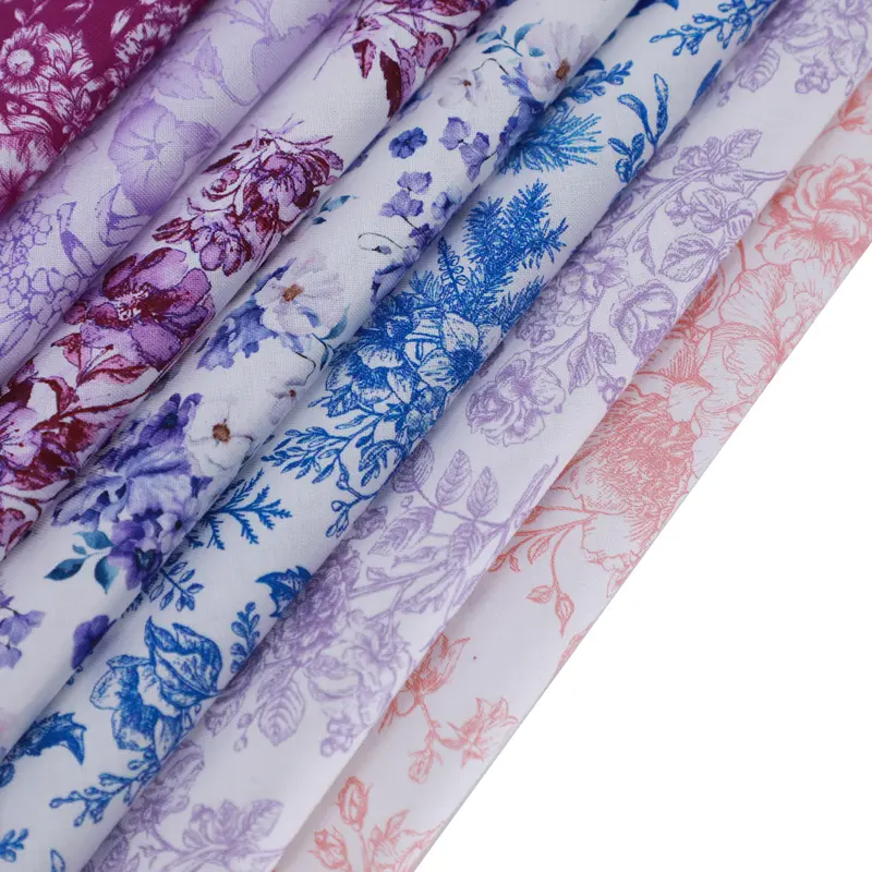 Rolls of floral-patterned fabric in various colors on a white background