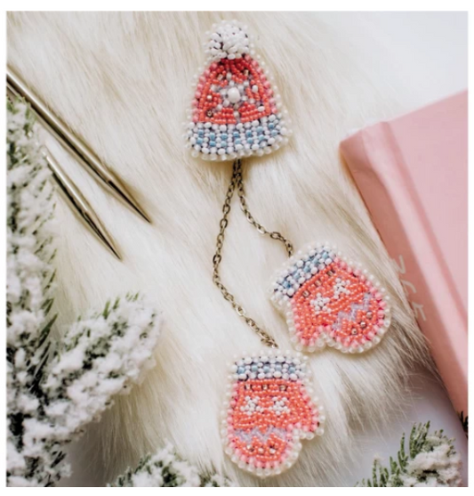 Decorative earrings with beadwork on a fluffy white surface