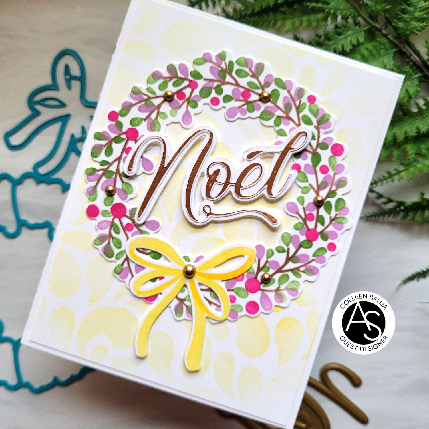 Greeting card with 'Noel' text and floral wreath design on a white background.