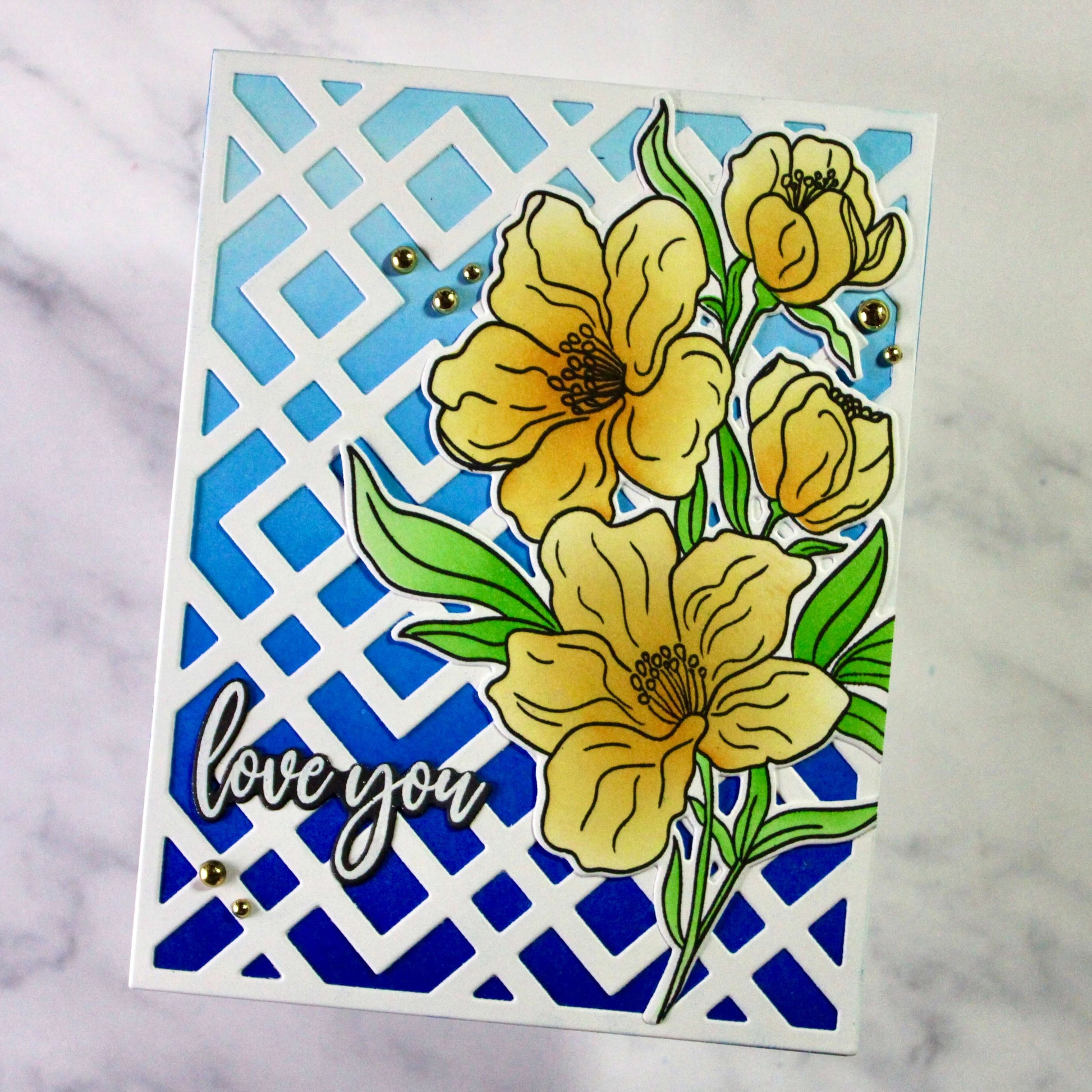 Card with yellow flowers and 'love you' text on a blue geometric patterned background