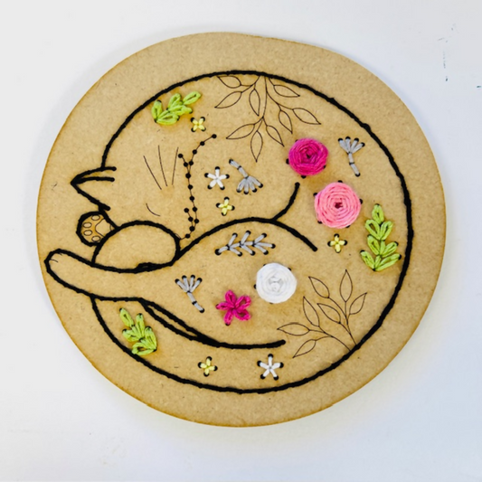 Embroidery design on cardboard with floral and leaf patterns