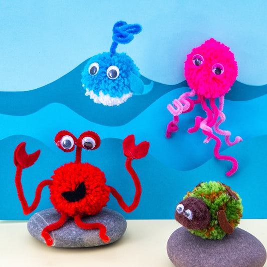 Colorful yarn creatures on stones with a blue wave background