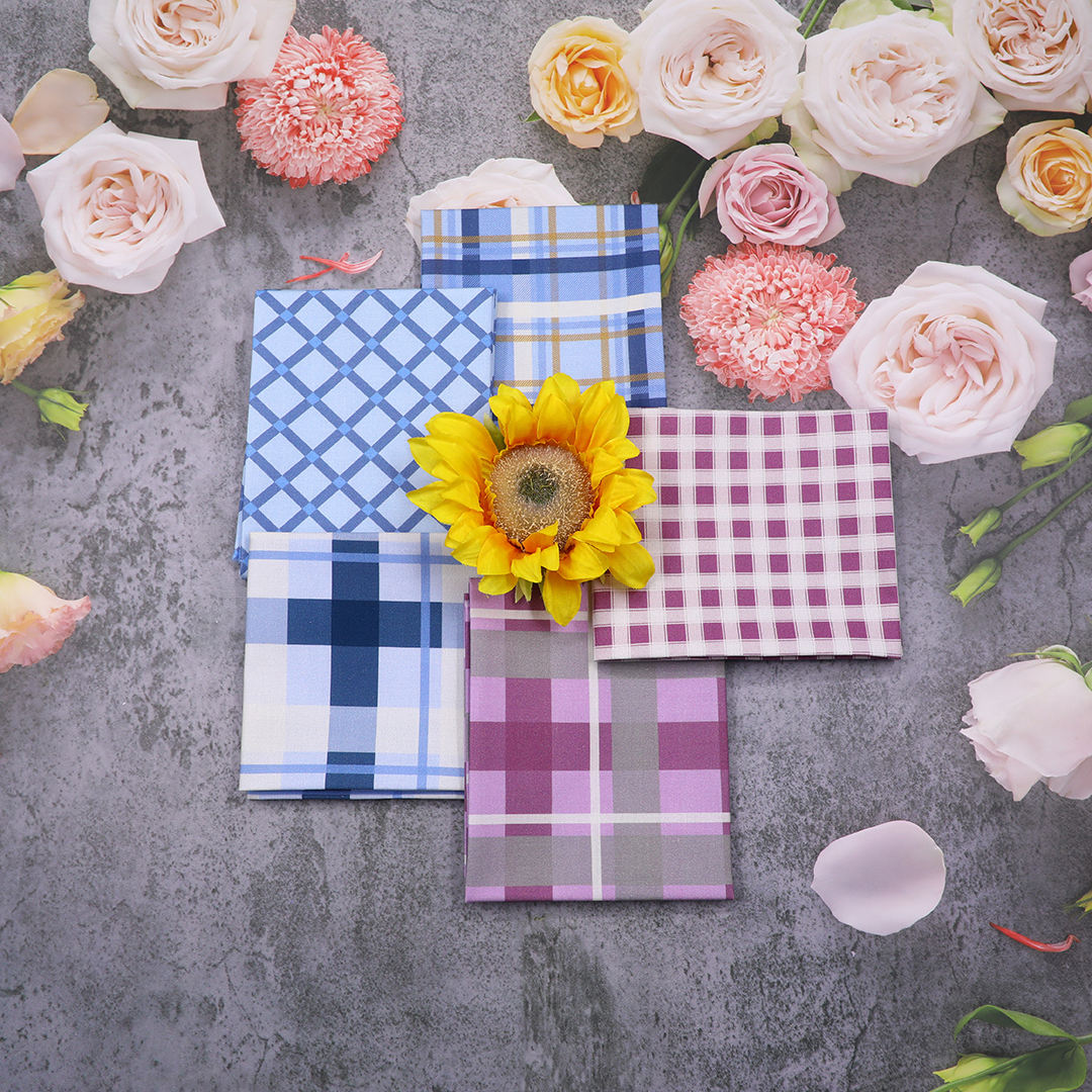 Plaid napkins with a sunflower on a gray surface surrounded by flowers