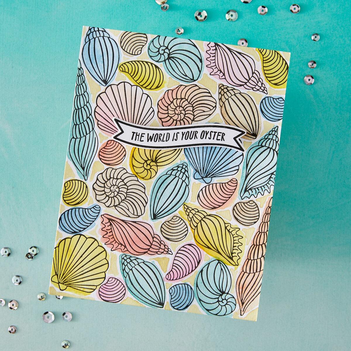 Colorful seashell patterned card with 'The World is Your Oyster' text on a turquoise background.
