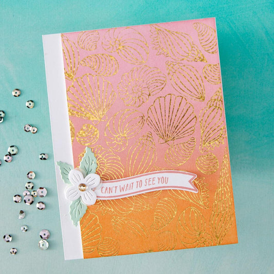 Card with gold shell pattern and floral design on a teal background