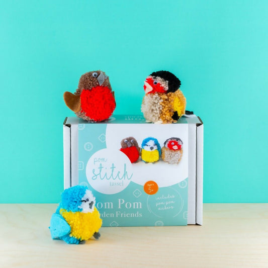 Colorful pom-pom birds in front of a 'Love Stitch' box on a light blue background