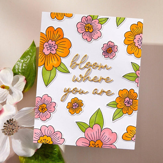 Card with floral design and 'bloom where you are' text, surrounded by flowers.