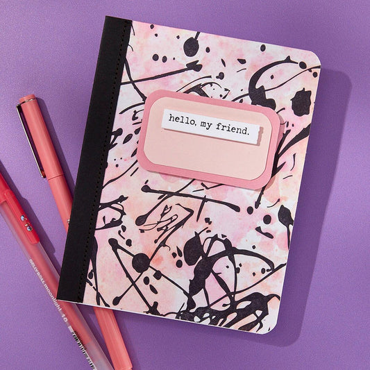 Notebook with abstract design and 'hello, my friend' tag on a purple background