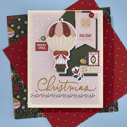 Spellbinders Merry Moments Limited Edition Holiday Card Making Kit Christmas-themed card with hot air balloon design on a blue background