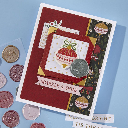 Spellbinders Decorative Christmas card with festive design and coins on a blue background