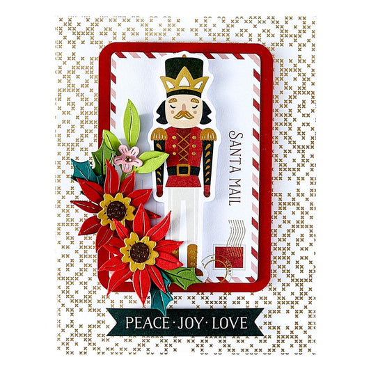 Spellbinders Decorative card with a nutcracker, flowers, and 'Peace Joy Love' text on a patterned background.