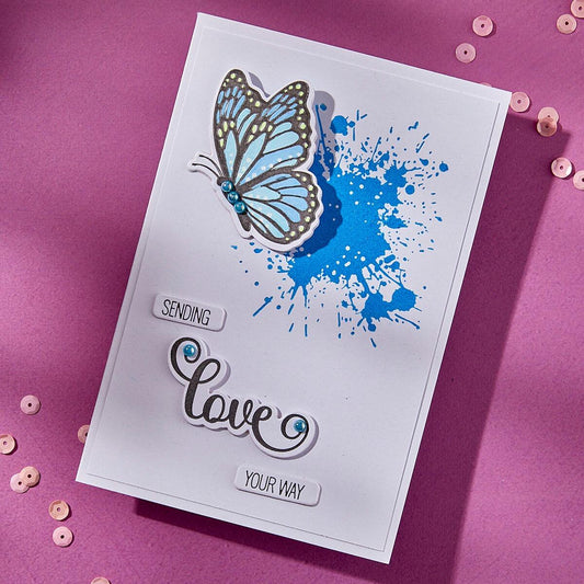 Greeting card with blue butterfly and 'Sending love your way' text on a pink background