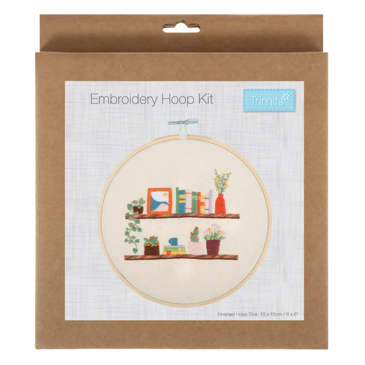 Embroidery hoop kit packaging with a design of a shelf and plants on a white background.