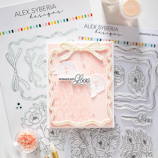 Clear stamp set with floral designs and a card featuring 'wrapped with love' text, branded 'Alex Syberia Designs'.