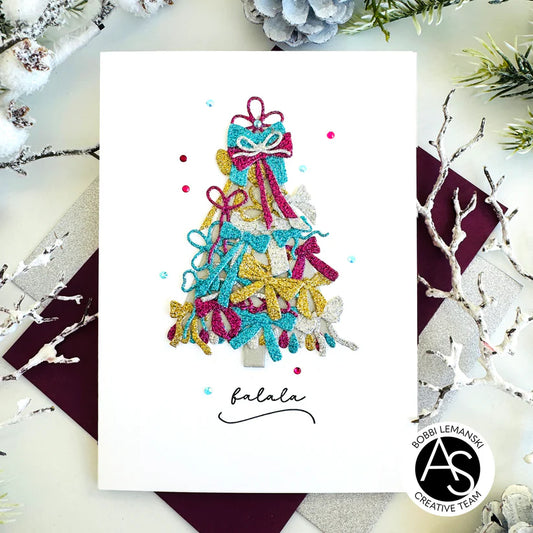 Colorful Christmas tree card with decorative bows on a white background, surrounded by holiday decorations.