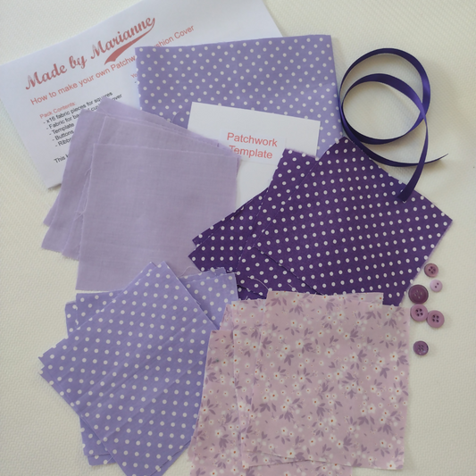 Purple fabric pieces with patterns, a ribbon, and buttons on a white background.