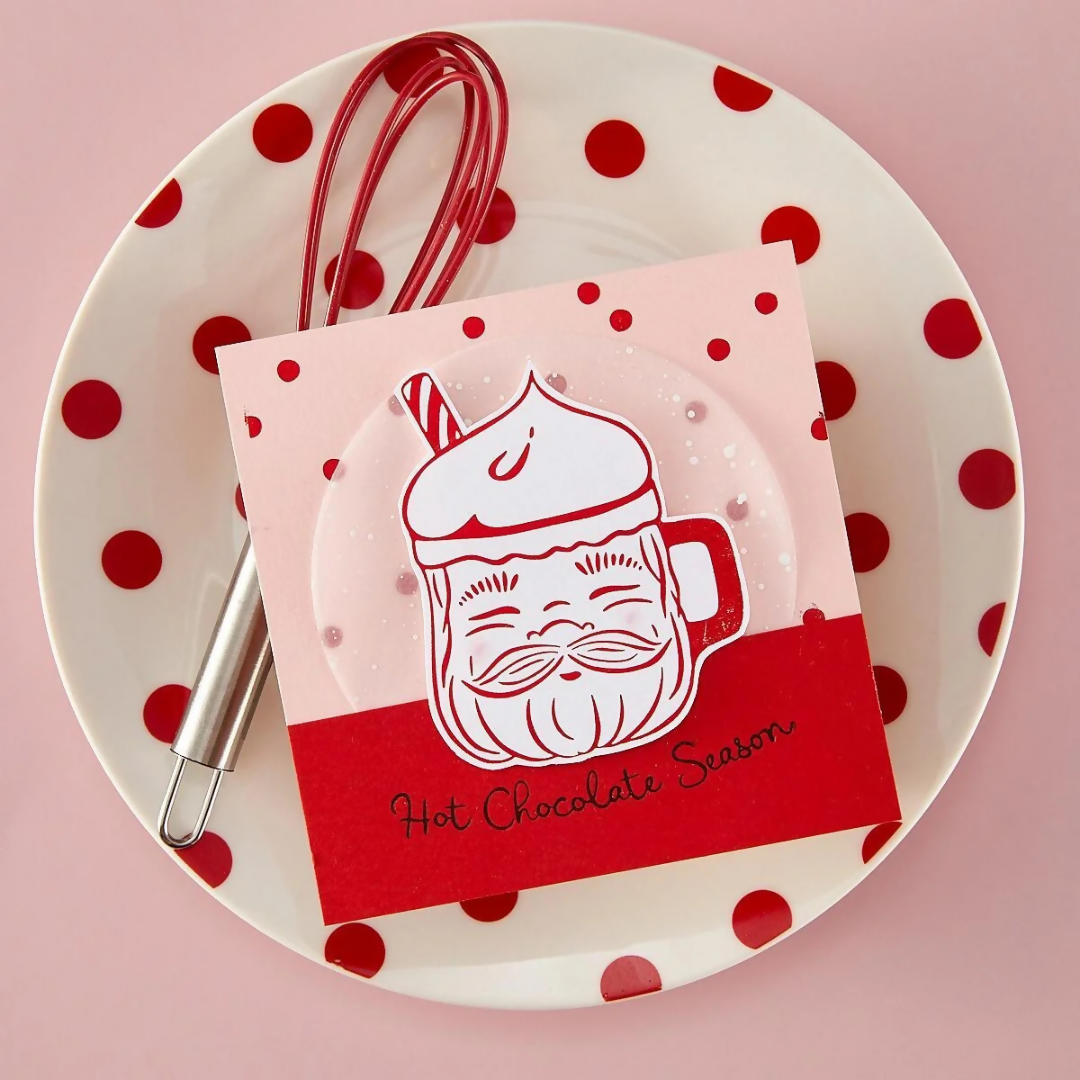 Card with hot chocolate illustration on a polka dot plate with a whisk