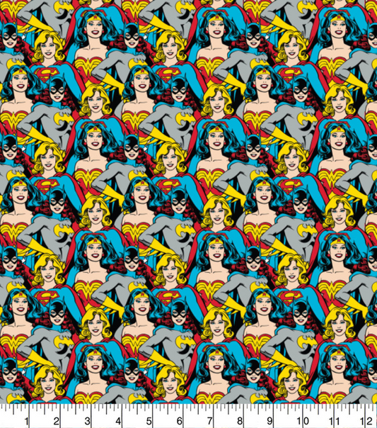 Pattern of superheroine characters on a fabric background with a ruler at the bottom.