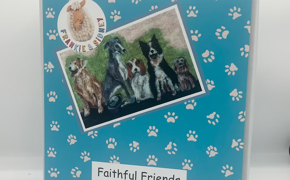 Card with embroidered picture of dogs on a blue background with paw prints