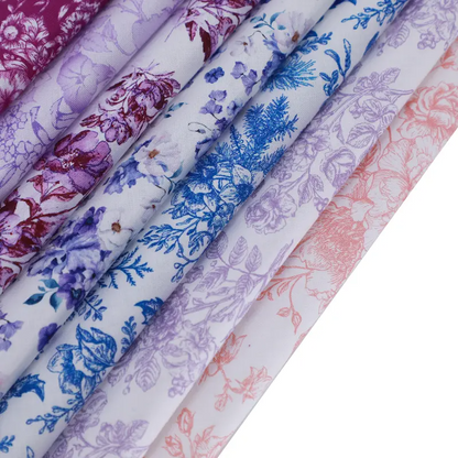 Rolls of floral-patterned fabric in various colors on a white background