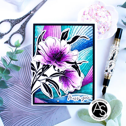 Card with a floral design and 'Miss you' message, surrounded by decorative items like scissors and a pen.