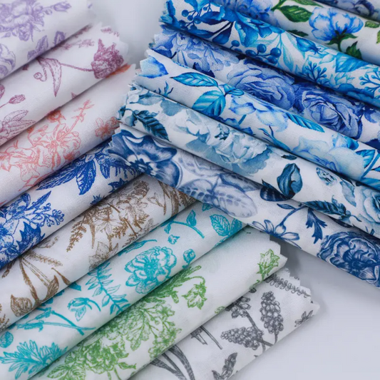 Collection of folded fabric swatches with various floral patterns on a white background
