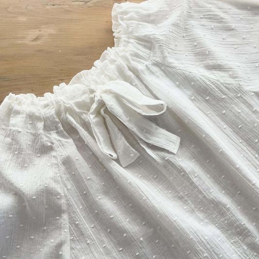 White fabric with a subtle pattern on a wooden surface