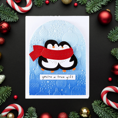 Christmas card with penguins and red scarf surrounded by festive decorations on a black background