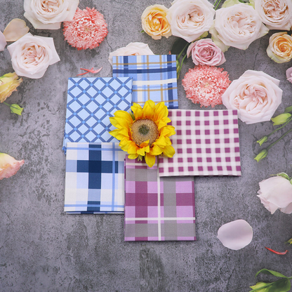 Plaid napkins with a sunflower on a gray surface surrounded by flowers