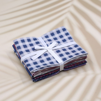Stack of folded fabric with a white ribbon on a beige surface