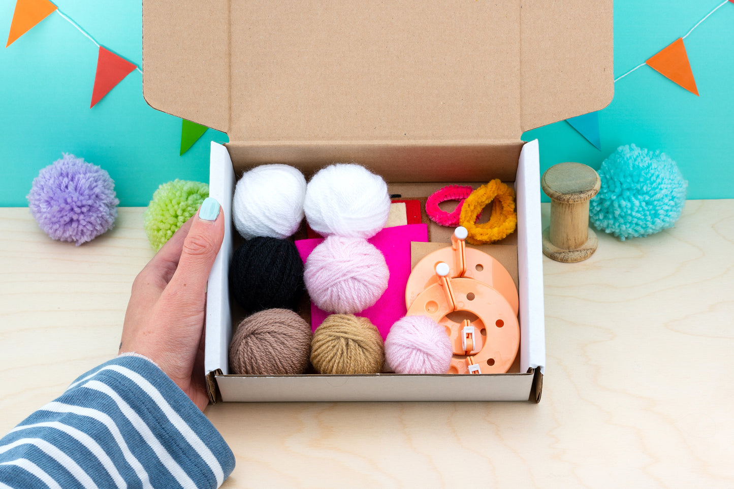 Box of yarn and knitting accessories on a colorful background