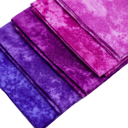 Stack of purple and pink fabric swatches on a white background