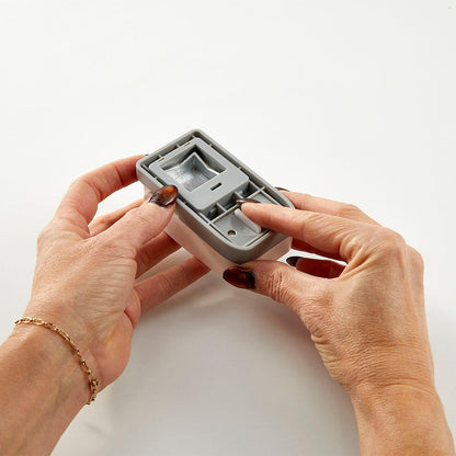Person holding a Spellbinders 1" Square Punch Tool with a white background