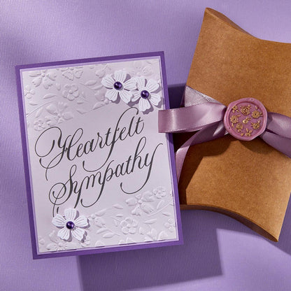 Sympathy card with flowers and a brown envelope on a purple background