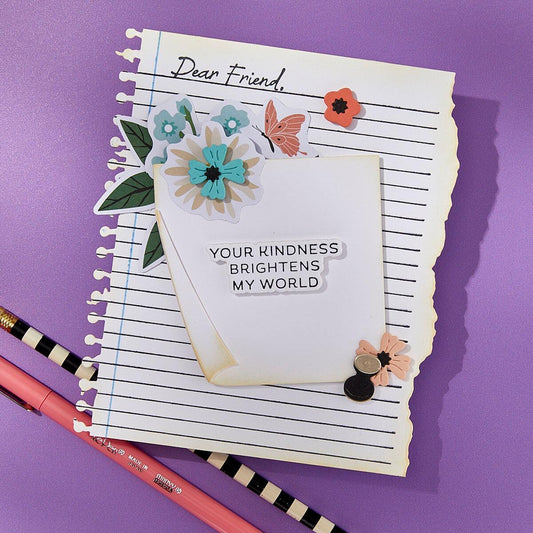 Notebook with decorative flowers and a card on a purple background
