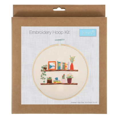 Embroidery hoop kit packaging with a design of a shelf and plants on a white background.