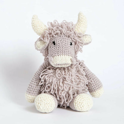 Knitted toy cow on a white background