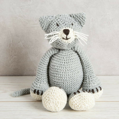 Knitted cat toy on a wooden surface with a neutral background