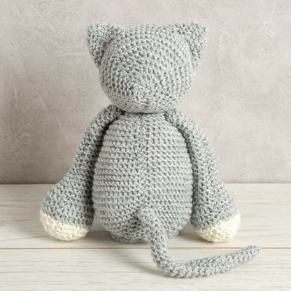 Knitted cat toy on a wooden surface with a neutral background