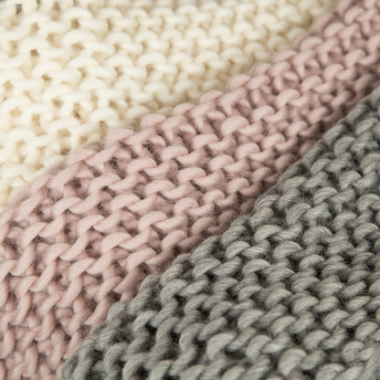 Close-up of three knitted fabrics in beige, pink, and gray.