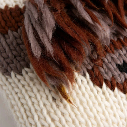 Close-up of a knitted fabric with brown, beige, and white colors.