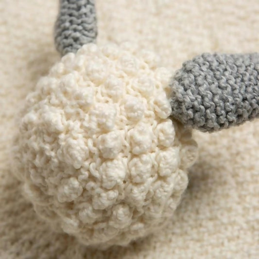 Close-up of a textured white ball with gray accents on a beige background