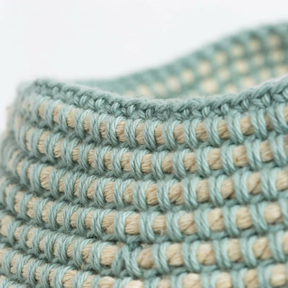 Close-up of braided green and beige cord on a white background
