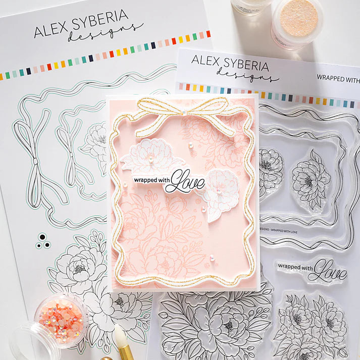 Clear stamp set with floral designs and a card featuring 'wrapped with love' text, branded 'Alex Syberia Designs'.