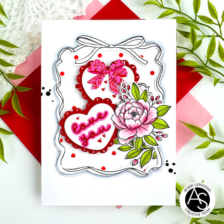 Decorative die cut with hearts, flowers, and bows on a white card with decorative elements.
