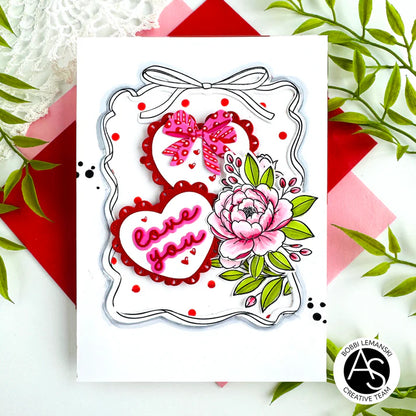 Decorative die cut with hearts, flowers, and bows on a white card with decorative elements.