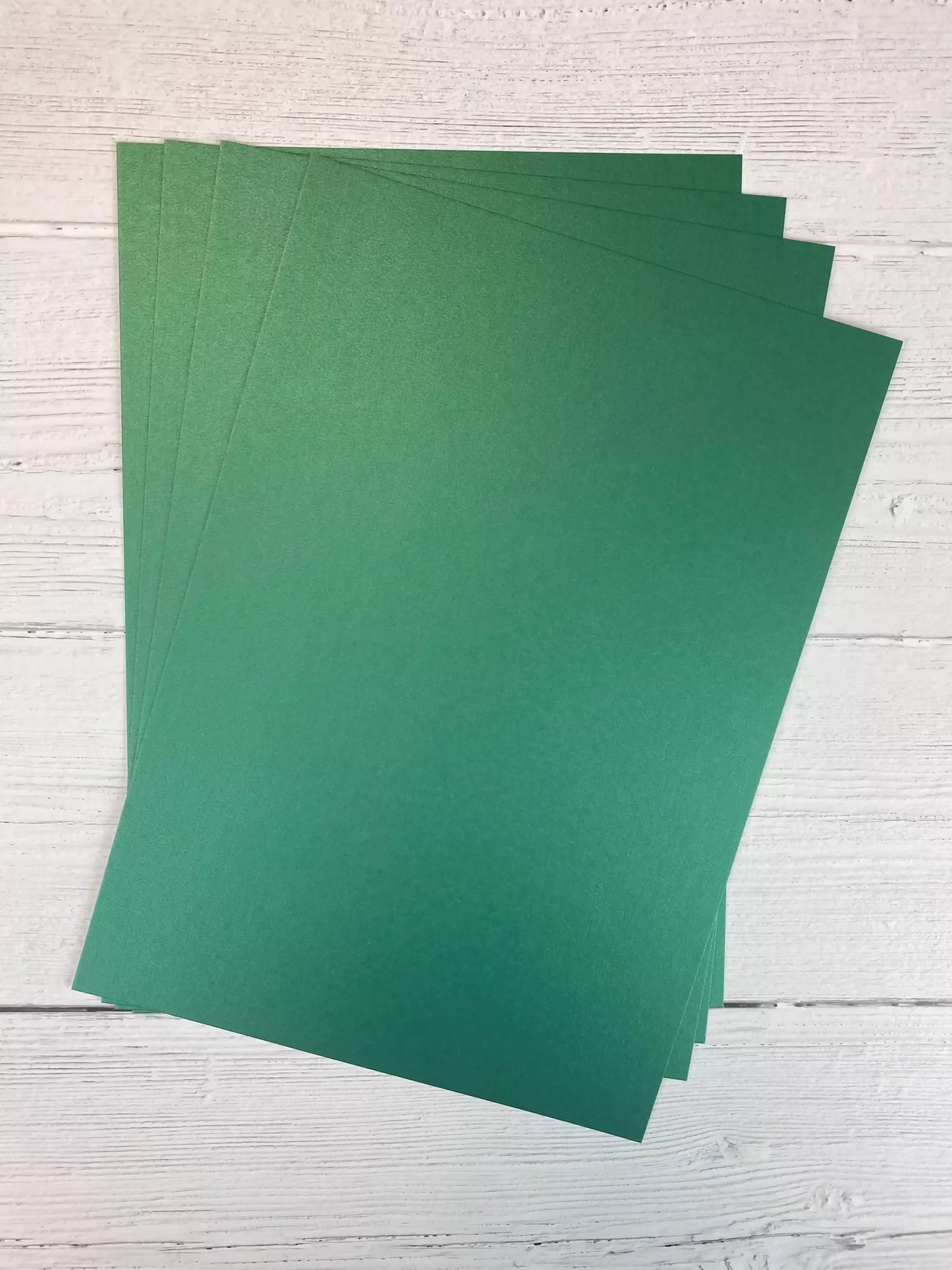 Stack of green sheets on a light wooden surface