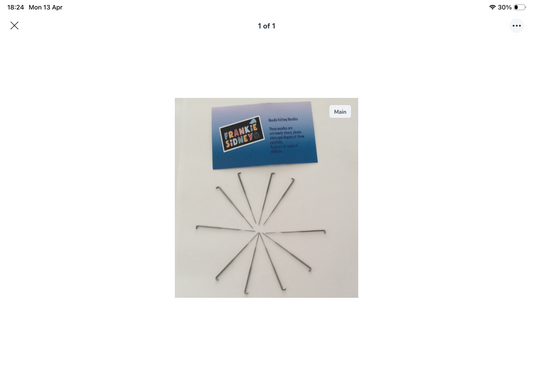 Set of metal pins on a white card with a brand label.