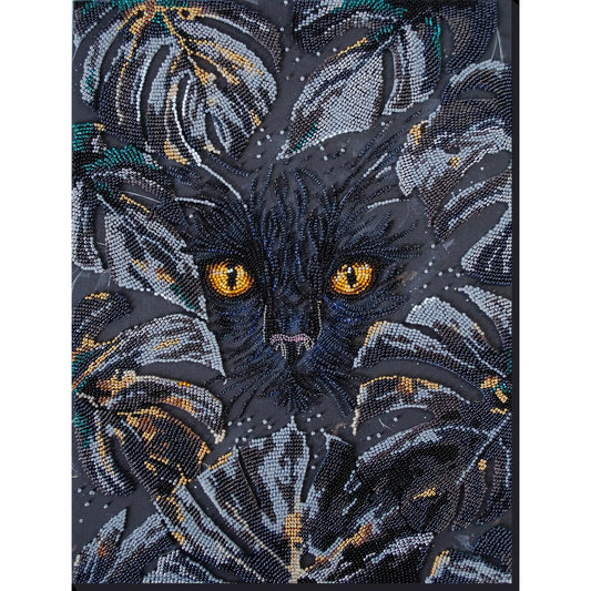 Embroidered design of a cat's face with intricate details on a dark background